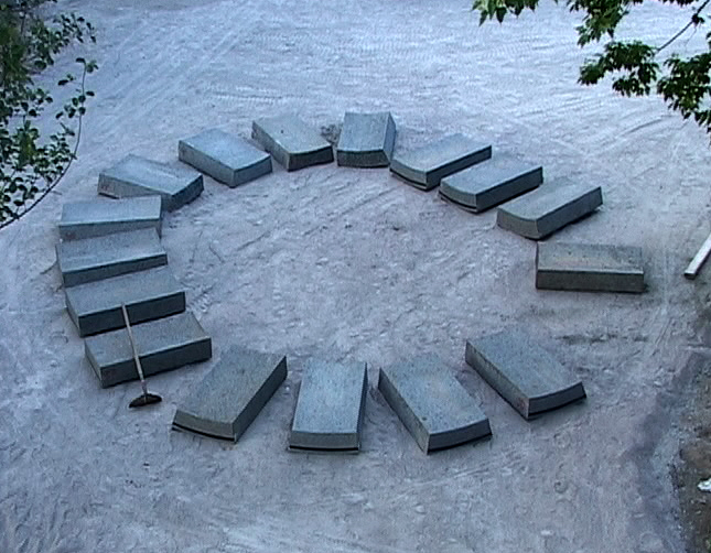 Concrete slabs arranged in a circle on sandy ground