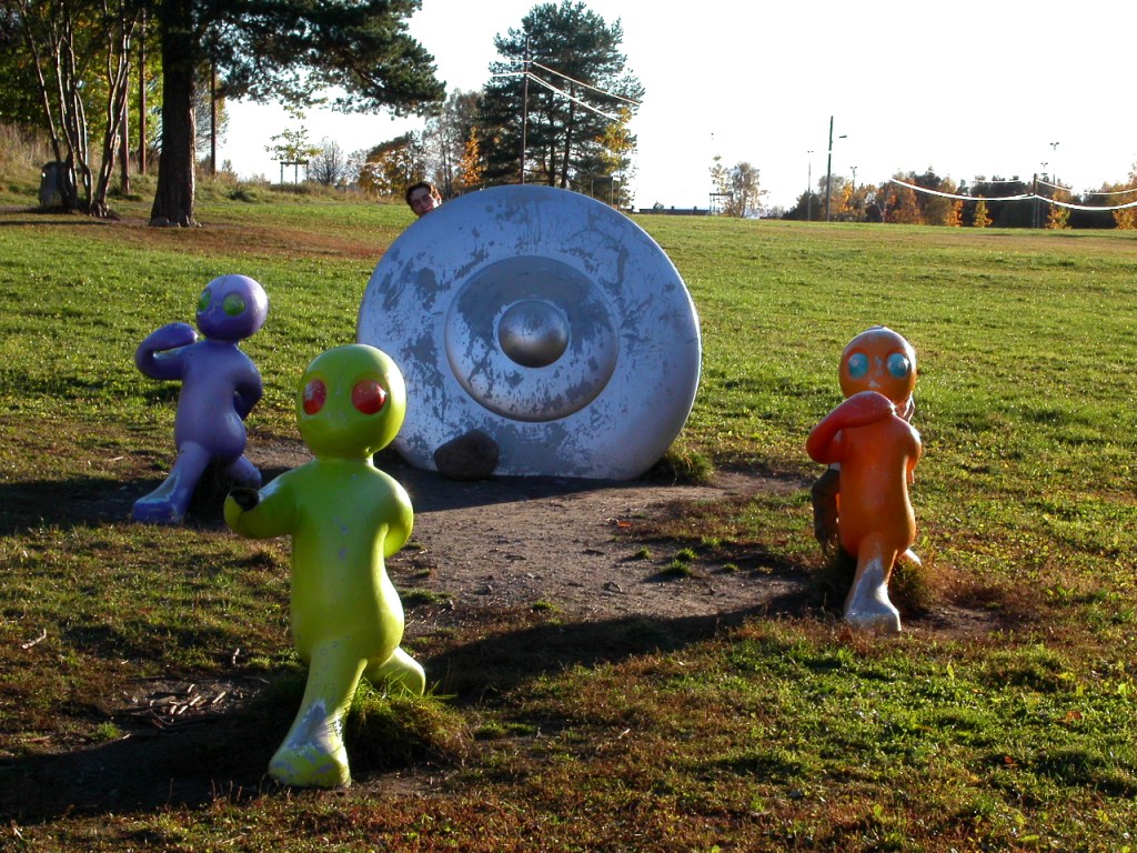 Colourful alien figures and flying saucer sculpture in a park
