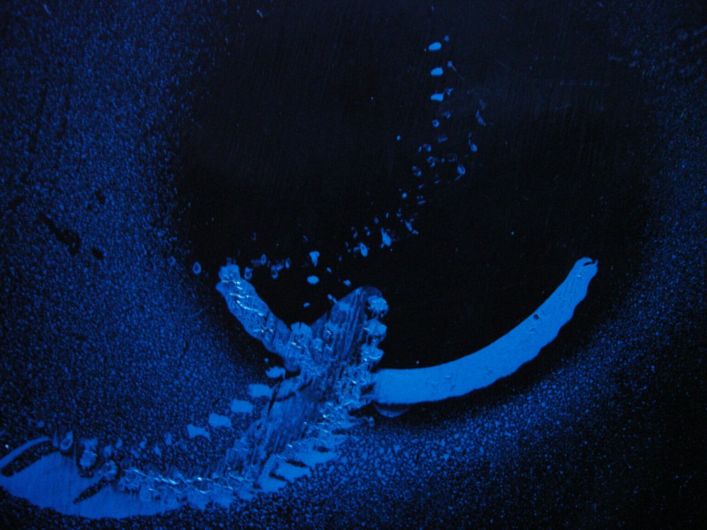 Abstract blue glowing paint strokes on a dark surface